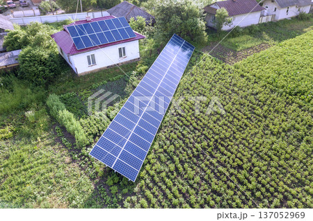 Aerial view of a house with blue solar panels for clean energy. 137052969