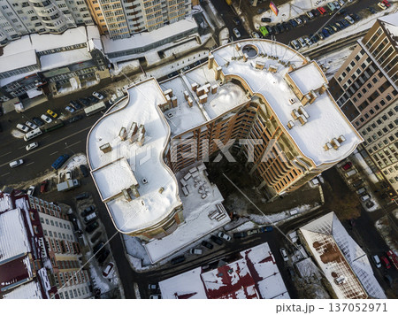 Aerial black and white winter panoramic top view of modern city with tall apartment complex buildings snowy roof, parked and moving cars along streets. Urban infrastructure, view from above. Aerial black and white winter panoramic top view of modern city with tall apartment complex buildings snowy roof, parked and moving cars along streets. Urban infrastructure, view from above. 137052971