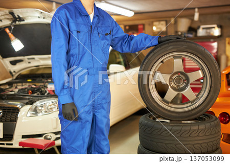 工場でタイヤ交換をする自動車整備士 工場でタイヤ交換をする自動車整備士 137053099