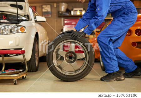 工場でタイヤ交換をする自動車整備士 工場でタイヤ交換をする自動車整備士 137053100