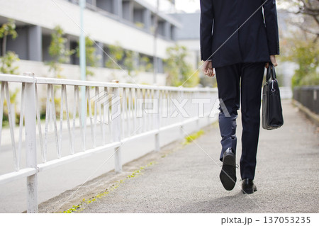 屋外を歩く20代のビジネスマン 屋外を歩く20代のビジネスマン 137053235