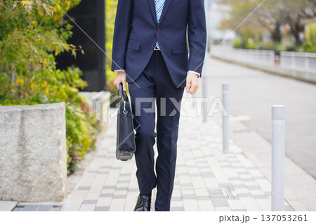 屋外を歩く20代のビジネスマン 137053261
