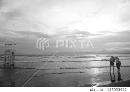 夕暮れの海岸を歩く人 夕暮れの海岸を歩く人 137053481