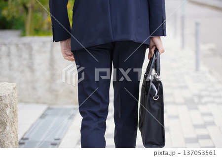 屋外を歩く20代のビジネスマン 屋外を歩く20代のビジネスマン 137053561