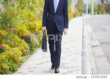 屋外を歩く20代のビジネスマン 137053565