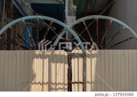 トタンを貼りつけた古く赤錆びた鉄の門 137054380