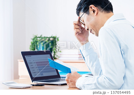 年金手帳を見ながら考える中高年男性 137054495