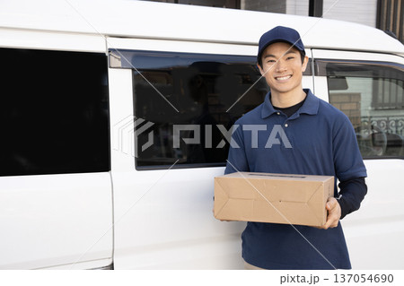 笑顔で荷物を届ける宅配便の男性 笑顔で荷物を届ける宅配便の男性 137054690