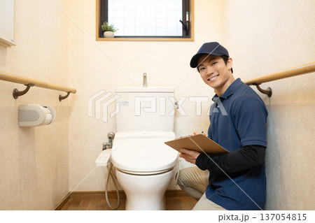 トイレの清掃の見積もりをするハウスクリーニングの男性 トイレの清掃の見積もりをするハウスクリーニングの男性 137054815