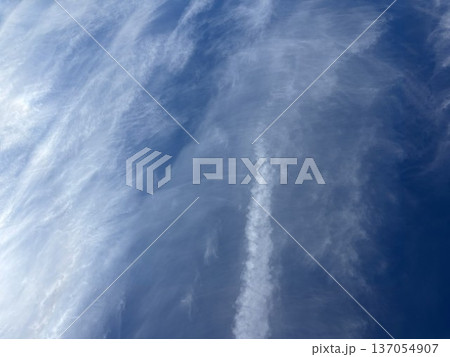 澄み渡る濃い青空に広がる白いベールのような筋雲や飛行機雲が描く美しい模様のテクスチャ背景 137054907