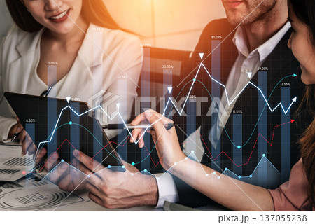 Business professionals analyzing financial data with tablet and graphs, discussing strategies and insights, office environment, teamwork concept Scalp 137055238