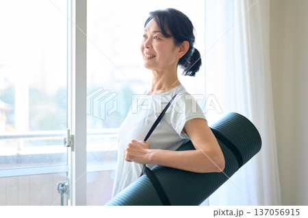 ヨガマットを持つ女性 137056915