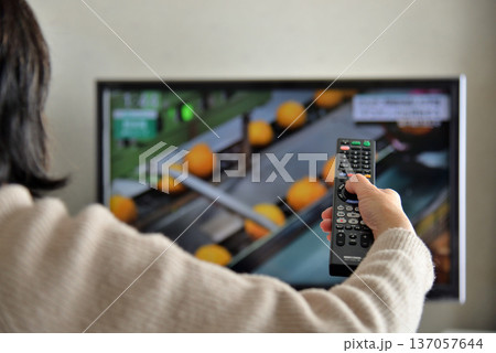 テレビのリモコンを操作するシニア女性 137057644