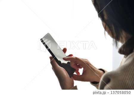 携帯電話を操作するシニア女性 137058050