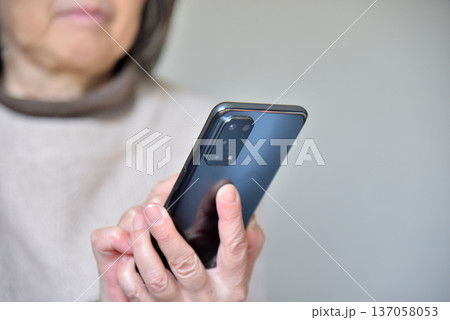 携帯電話を操作するシニア女性 携帯電話を操作するシニア女性 137058053