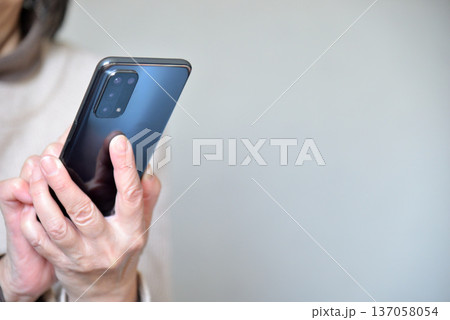 携帯電話を操作するシニア女性 137058054