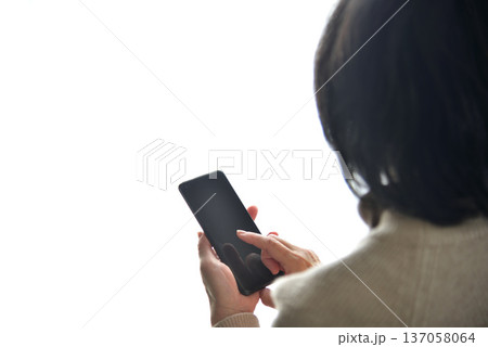 携帯電話を操作するシニア女性 137058064
