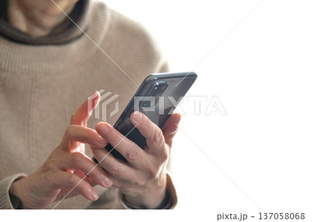 携帯電話を操作するシニア女性 携帯電話を操作するシニア女性 137058068