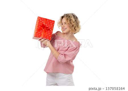 Woman enjoys presenting a red gift box with a bow, isolated, PNG Woman enjoys presenting a red gift box with a bow, isolated, PNG 137058164
