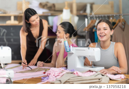 Young woman using sewing-machine at dressmaking courses Young woman using sewing-machine at dressmaking courses 137058218