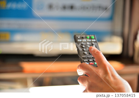 テレビのリモコンを操作するシニア女性 137058415