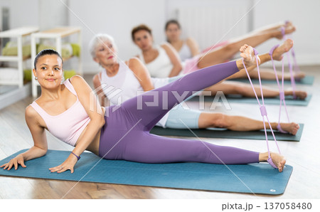 Asian woman doing Pilates exercises with figure eight resistance tube Asian woman doing Pilates exercises with figure eight resistance tube 137058480