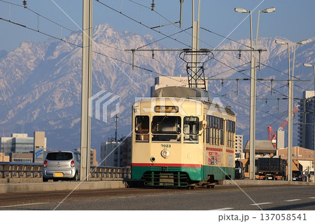 【富山地方鉄道】立山連峰と7000形（市内電車：安野屋〜トヨタモビリティ富山 Gスクエア五福前） 137058541