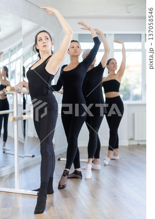 Group of women practicing at ballet barre Group of women practicing at ballet barre 137058546