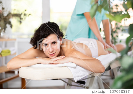 Portrait of woman relaxing on massage table at spa center 137058557