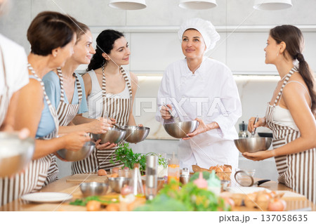 Young woman chef teaches cooking at master class Young woman chef teaches cooking at master class 137058635