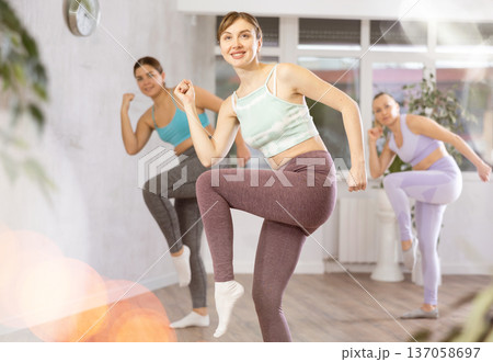 Cheerful women practicing sporty dances in gym Cheerful women practicing sporty dances in gym 137058697
