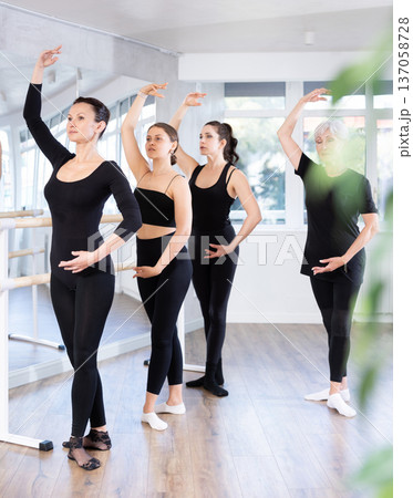 Fit woman maintaining fourth position during ballet workout 137058728