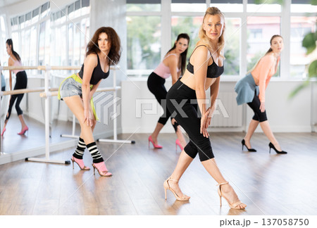 During lesson, woman learn to move and perform dance in heels with women companions 137058750