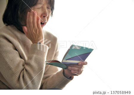 預金通帳 貯金通帳を確認するシニア 137058949