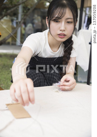 マルシェでワークショップをする若い女性 マルシェでワークショップをする若い女性 137059208