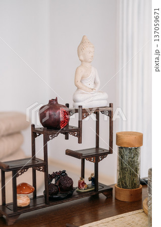 Traditional buddha statue. Herbal tea ceremony. Healthy drink transparent brew water tasty pomegranate liquid clear cup glass teapot for calming fresh beverage. 137059671
