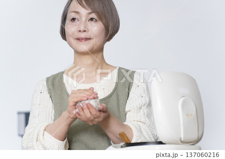 キッチンでおにぎりを握るシニア女性 キッチンでおにぎりを握るシニア女性 137060216