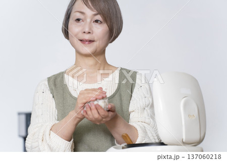 キッチンでおにぎりを握るシニア女性 137060218