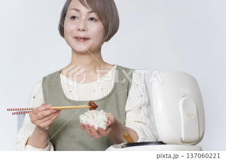 キッチンでおの義理を握るシニア女性 キッチンでおの義理を握るシニア女性 137060221