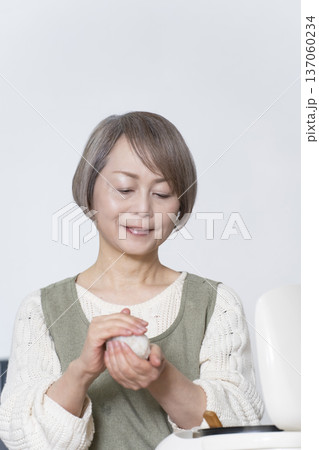 キッチンでおにぎりを握るシニア女性 137060234