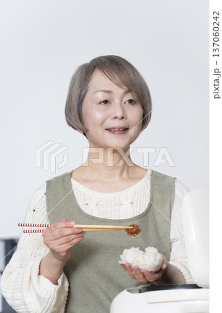 キッチンでおにぎりを握るシニア女性 キッチンでおにぎりを握るシニア女性 137060242