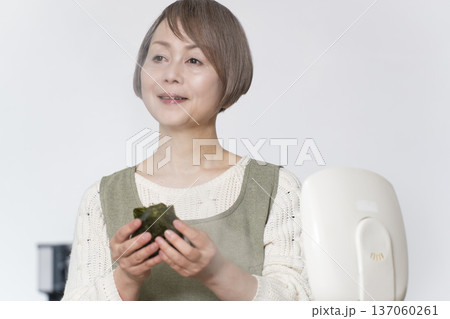 キッチンでおにぎりを握るシニア女性 キッチンでおにぎりを握るシニア女性 137060261