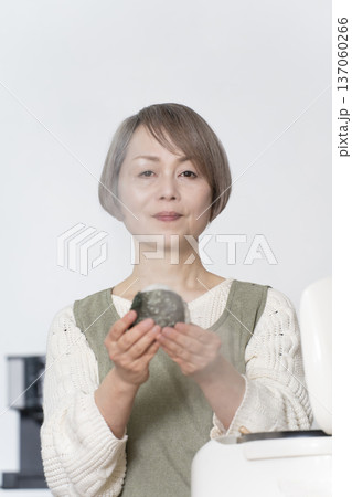 キッチンでおにぎりを握るシニア女性 キッチンでおにぎりを握るシニア女性 137060266