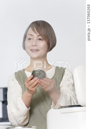 キッチンでおにぎりを握るシニア女性 137060268