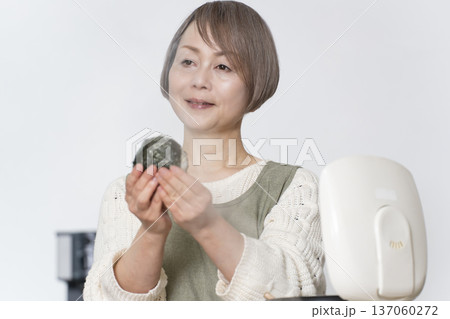 キッチンでおにぎりを握るシニア女性 キッチンでおにぎりを握るシニア女性 137060272