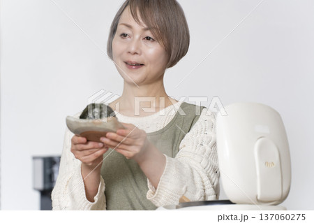 キッチンでおにぎりを握るシニア女性 137060275