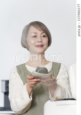 キッチンでおにぎりを握るシニア女性 キッチンでおにぎりを握るシニア女性 137060277