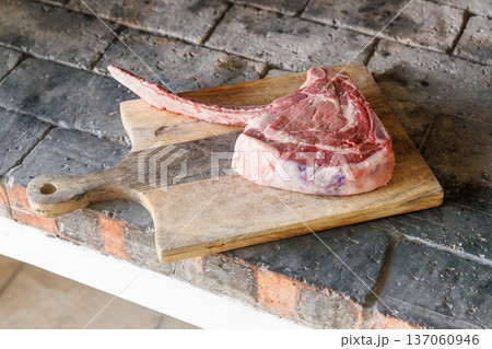 Raw tomahawk steak on cutting board 137060946