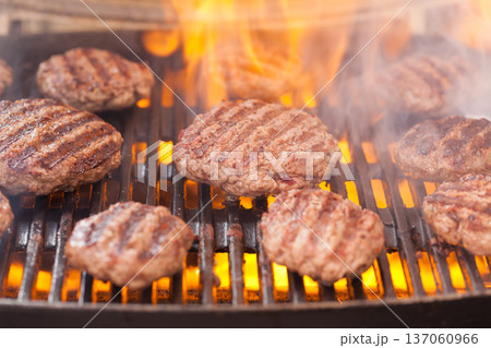 Burger patties grilling with fire and smoke Burger patties grilling with fire and smoke 137060966