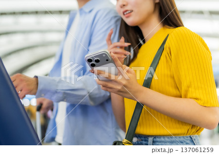空港でスマホ操作する二人 _■撮影協力:関西国際空港(KIX) 空港でスマホ操作する二人 _■撮影協力:関西国際空港(KIX) 137061259